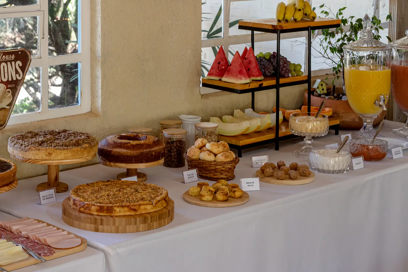 Bolos, tortas, salgados, frutas e sucos no café da manhã